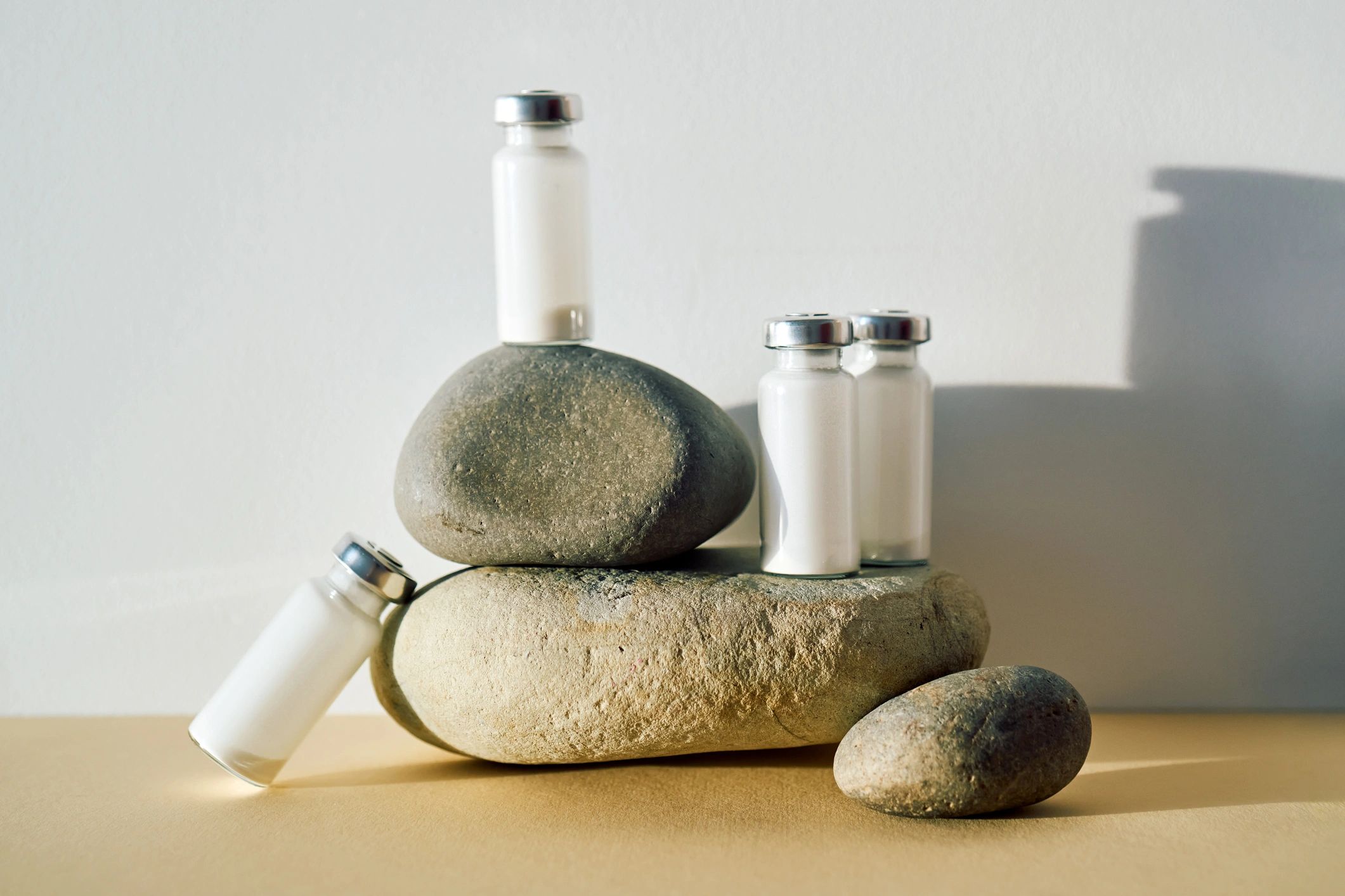 Medical vials with powder balanced on stones